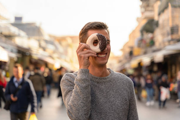 istock young man eating a donut in an alley 1168122887