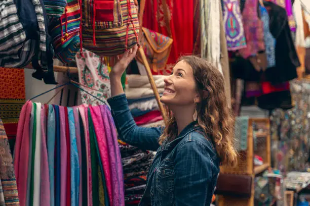 woman looking at colorful clothes in a bazaar in the middle east