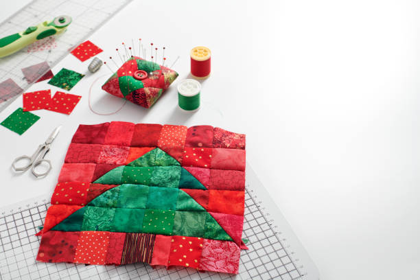 christmas tree patchwork block, bright square pieces of fabric, pincushion, quilting and sewing accessories on white background - christmas quilt craft patchwork imagens e fotografias de stock