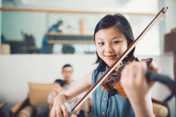 asiática niña tocando el violín en casa. - violin family fotografías e imágenes de stock