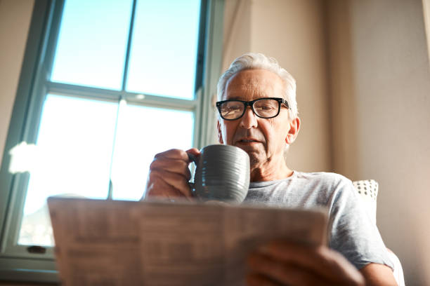 mantenerse al día con las noticias - newspaper glasses the media reading fotografías e imágenes de stock