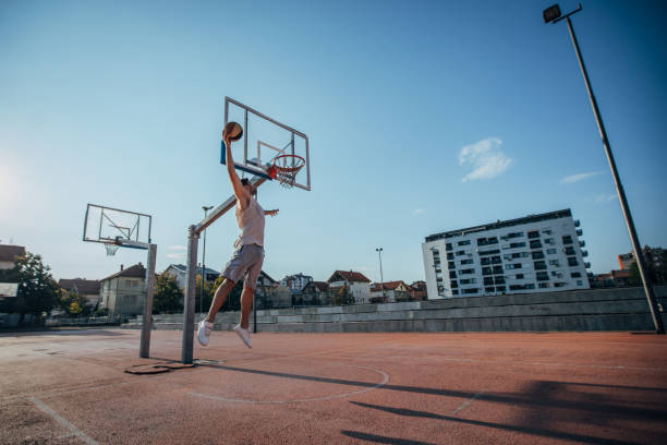 istock Man dunking on streetball court 1168138456