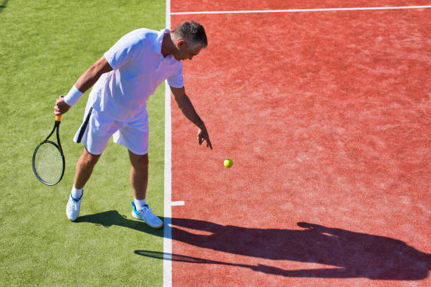 istock Confident mature man playing tennis on sunny day 1168143081