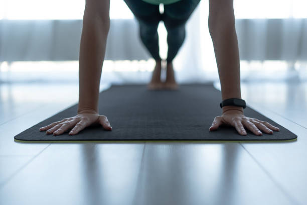 jeune femme sportive restant dans la pose de planche sur le tapis de forme physique - home fitness photos et images de collection