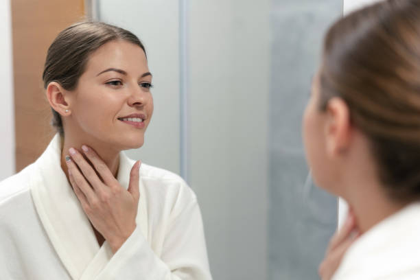 istock Woman in bathrobe looking in mirror at bathroom 1168144249