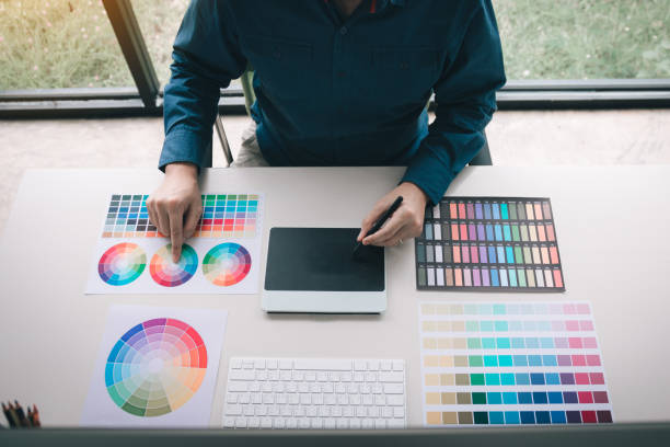 istock Freelance creative designers working on desk using digital graphic tablet and drawing with pen in modern home office. 1168145843