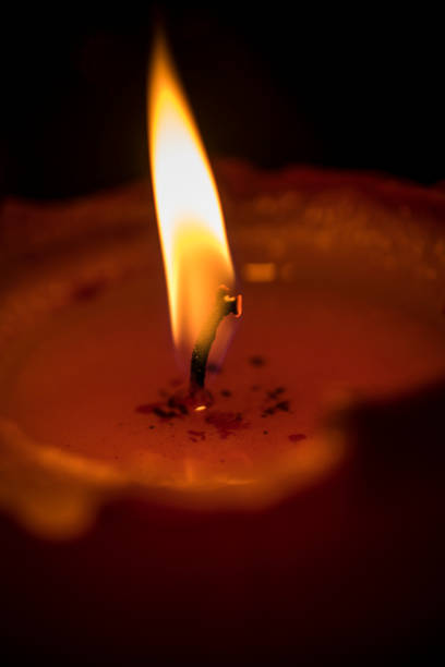 A close-up photo of a lit red candle