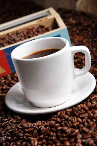 Photo of Coffee with grains and sweet bread. Coffee is a brewed drink prepared from roasted coffee beans, the seeds of berries from certain Coffea species.