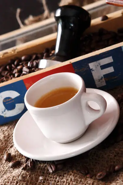 Photo of Coffee with grains and sweet bread. Coffee is a brewed drink prepared from roasted coffee beans, the seeds of berries from certain Coffea species.