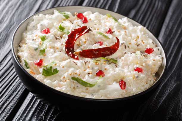 Indian Curd rice with carrots, pomegranate and with additional tempering of spices close-up in a plate. horizontal Indian Curd rice with carrots, pomegranate and with additional tempering of spices close-up in a plate on the table. horizontal curd cheese stock pictures, royalty-free photos & images