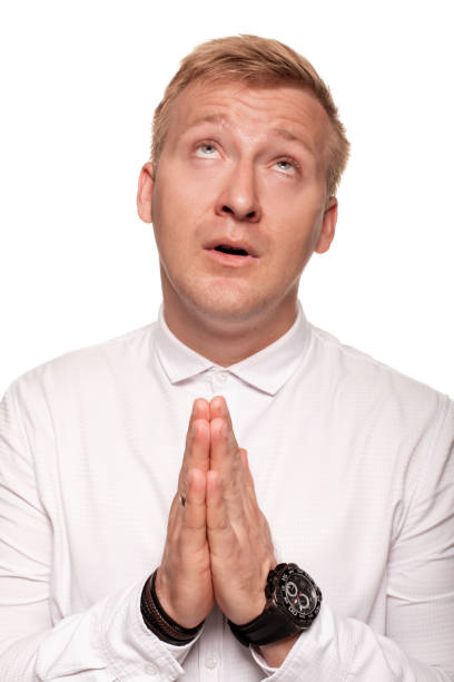 istock Imposing, young, blond man in a white shirt is grimacing while standing isolated on a white background 1168155473