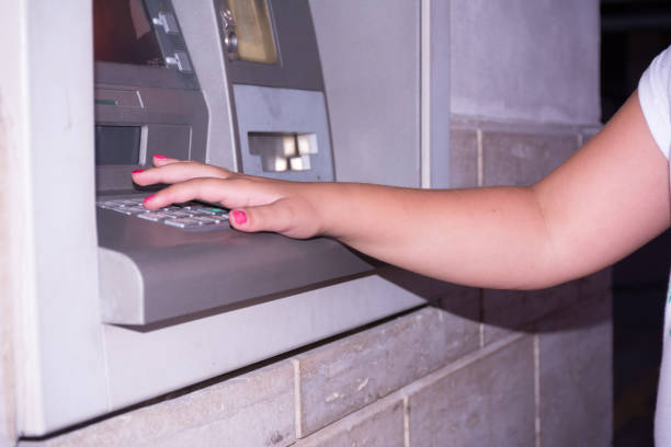 istock Close Up of Hand That Types a Code on the ATM Panel to Withdraw Cash on Blur Background at Night 1168158475