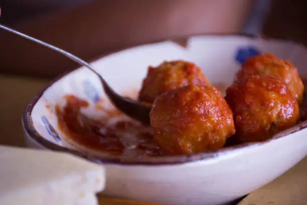 Close Up of Italian Traditional Food Called Polpette col Sugo, Made with Cheese, Meat and Tomato on Blurred Background