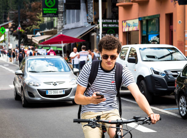 young man riding on a bmx bike on a back rear wheel, doing tricks in the city