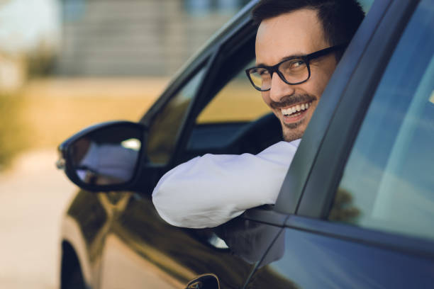 istock Businessman is looking at camera through the car window 1168161093