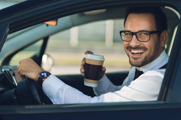 istock Businessman looking at camera through the car 1168161163