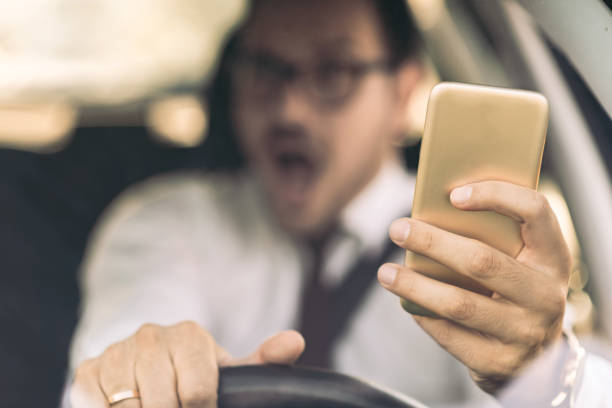 istock Frightened businessman holding a cell phone while driving a car 1168162337
