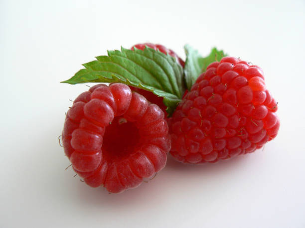 istock Fresh raspberries with leaves isolates on white background. 1168164043