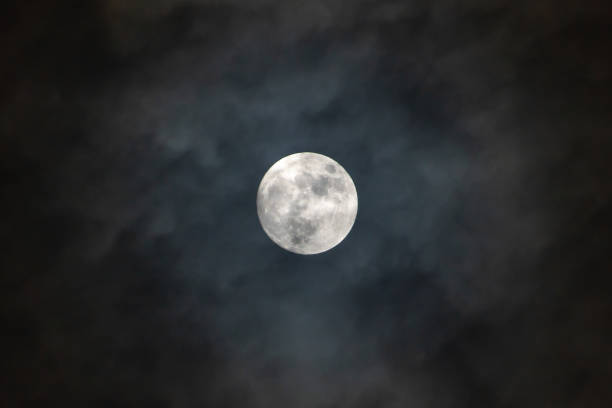 istock Full moon on the dark night shining on the sky in cloudy day. 1168166580