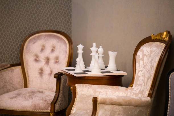 istock Beautiful classic interior, two armchairs and a coffee table with a candle decor in the form of chess. White chess candles 1168167112