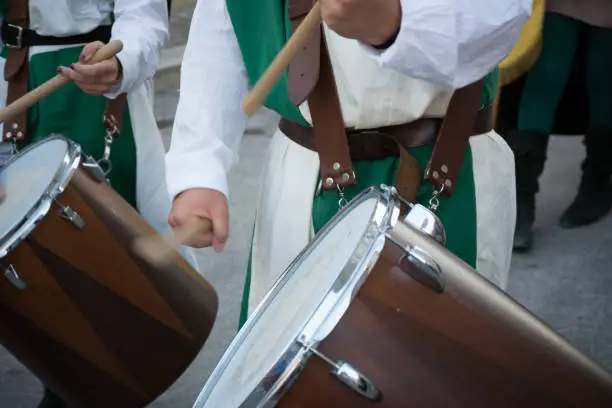 Photo of Close Up of Man Playing Drum at Medieval Village Festival on Blur Background