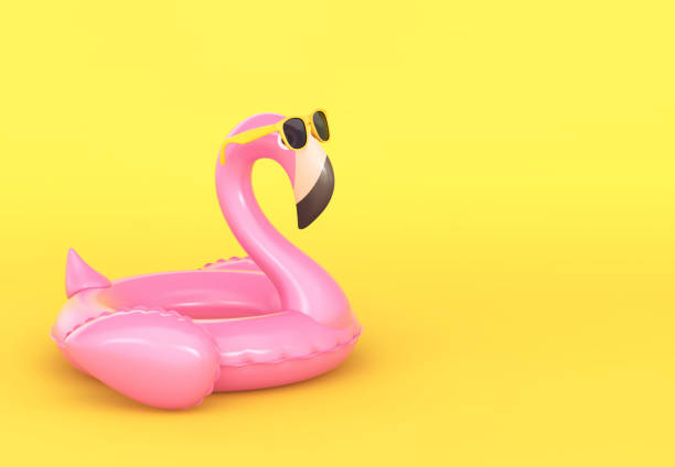 aufblasbarer flamingo in sonnenbrille auf gelbem hintergrund - float stock-fotos und bilder