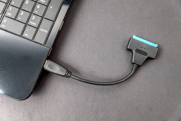 istock sata usb cable connected to laptop closeup overhead view on dark background 1168175736