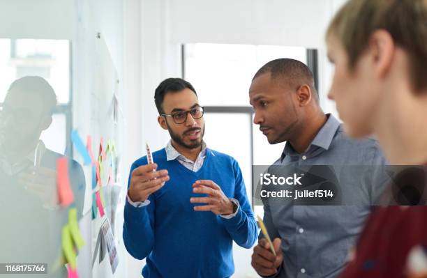 Portrait Of An Indian Man In A Diverse Team Of Creative Millennial Coworkers In A Startup Brainstorming Strategies Stock Photo - Download Image Now