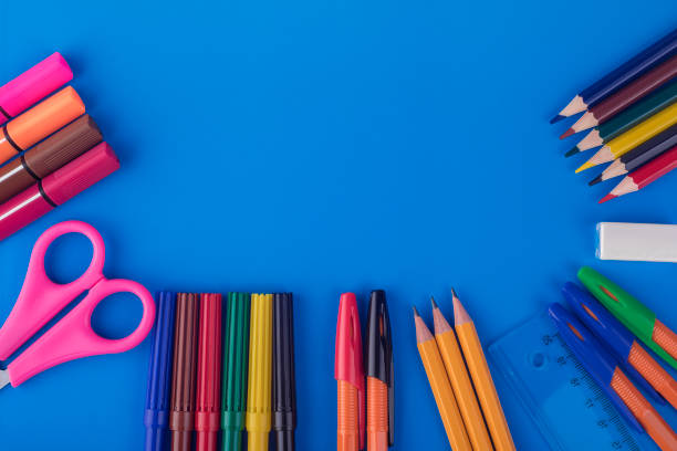 istock Colored pencils and pens laid out on a blue flatlay background 1168178276