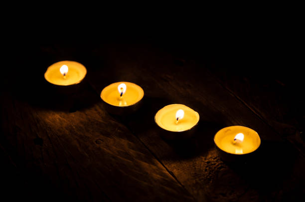 istock Candles in line burning on wooden table. 1168180485