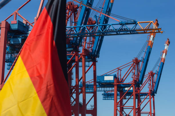 German flag in front of container quay and container ships in the harbor