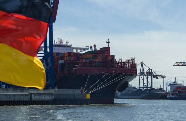 German flag in front of container quay and container ships in the harbor