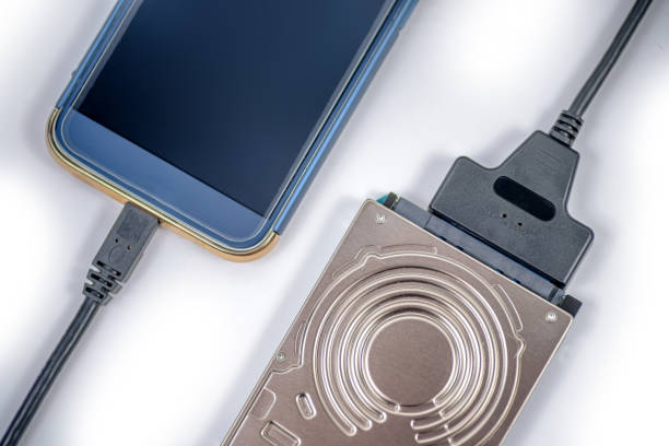 istock hdd 2.5 hard drive disk connected to smartphone via sata usb cable closeup overhead view 1168182432