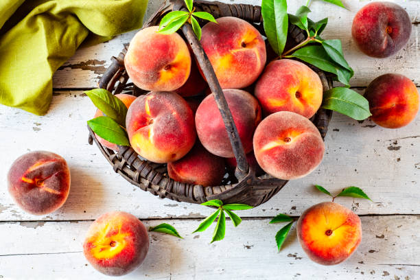 istock Fresh peaches in an old basket on a white wooden table 1168183062