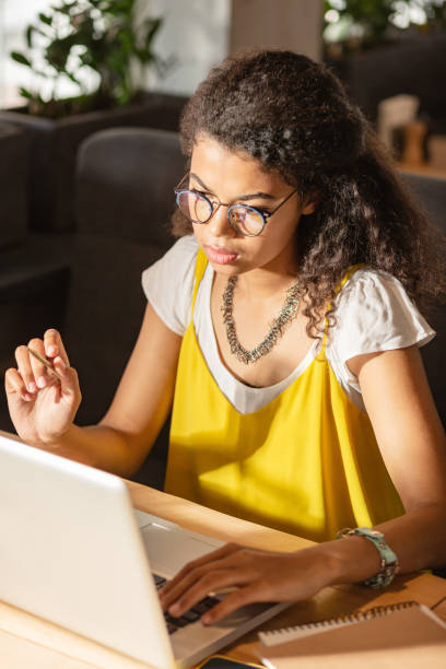 istock Serious young woman looking at the laptop screen 1168184298