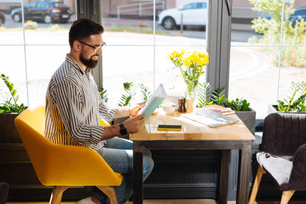 istock Delighted cheerful man looking into the book 1168184337