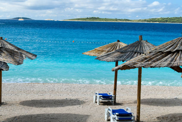 istock Sunshades and chairs on turquoise adriatic beach. 1168185075