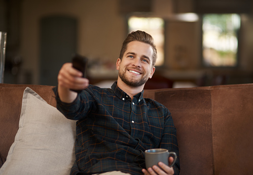 Cropped shot of a young man relaxing on the sofa at home