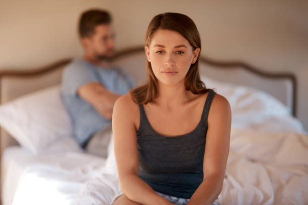 I think it's time for me to leave Shot of a young woman sitting on the edge of the bed after arguing with her husband irritation photos stock pictures, royalty-free photos & images