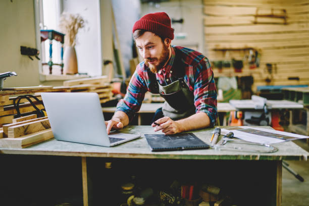 istock Young hipster guy satisfied with interesting webinar on laptop computer about craft spending time in workshop during courses, skilled handyman checking ordering of clients on email via netbook 1168188582