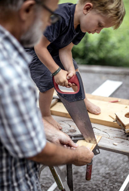 istock Grandfather and Grandson Making a Car From Wood 1168189064