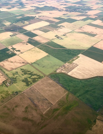 A patchwork quilt of fields taken from the sky, over Alberta, Saskatchewan and Manitoba, Canada.