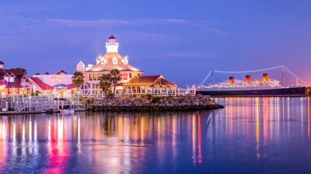 Summer Nights at Rainbow Harbor Long Beach, CA, USA - July 23th 2019: A summer evening overlooking the Parkers Lighthouse restaurant with the Queen Mary in the background. long beach california photos stock pictures, royalty-free photos & images