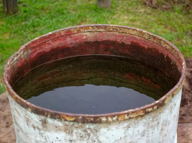 old iron barrel with water in the garden, Russia