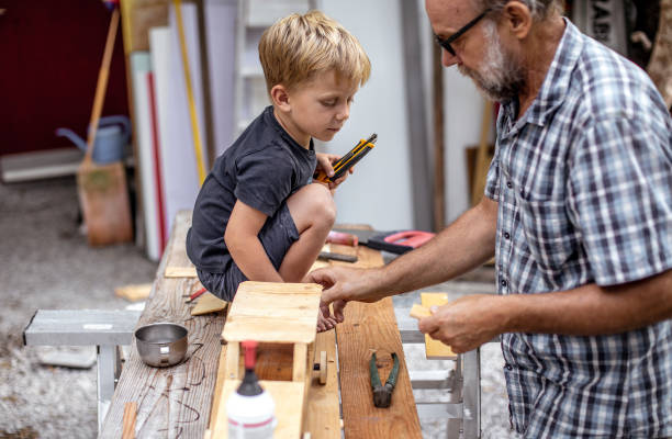 istock Grandfather and Grandson Making a Car From Wood 1168194178