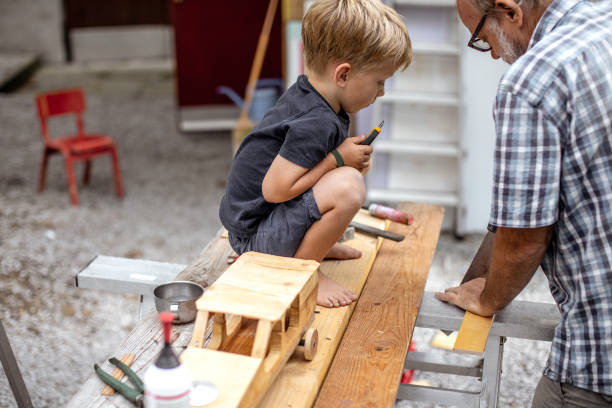 istock Grandfather and Grandson Making a Car From Wood 1168194312