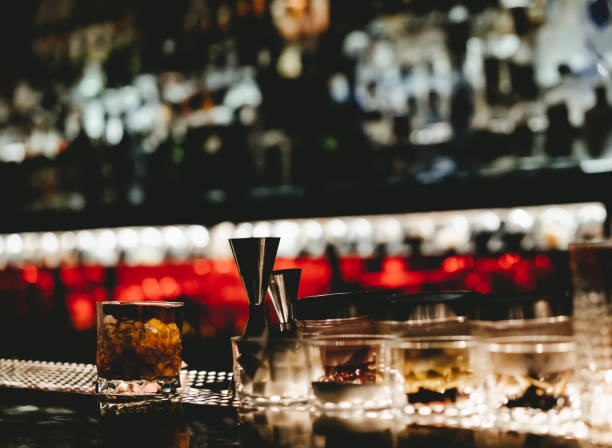 ドリンクやボトルが背景に積み重ねられたクラブ内のバーカウンターの内部図 - thailand restaurant cocktail bar ストックフォトと画像