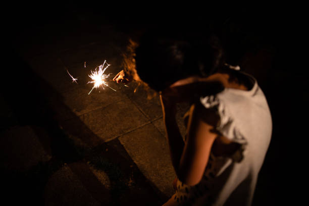 Girl playing with fireworks at night