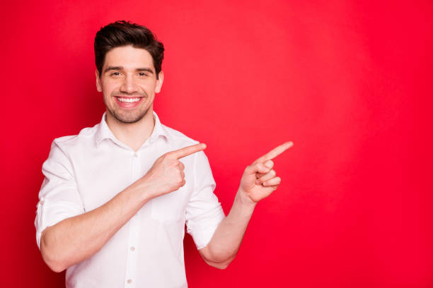 istock Close-up portrait of his he nice attractive cheerful cheery glad content guy executive director ceo boss chief pointing two forefingers aside ad isolated on bright vivid shine red background 1168201923