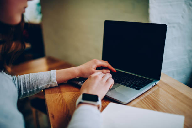 istock Cropped image of female freelancer using laptop computer for searching information and browsing website on blank monitor,woman using netbook application with mock up screen for e learning in cafe 1168203884